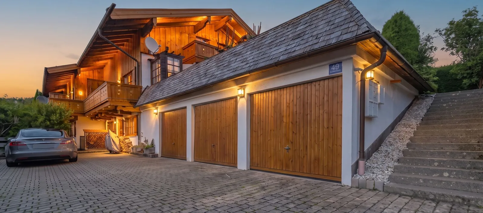 Alpines Holzhaus mit Garagen in der blauen Stunde