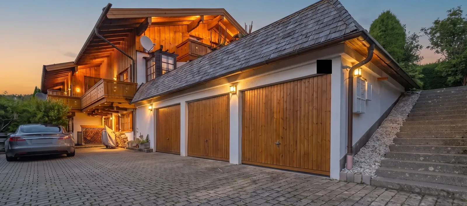 Alpines Holzhaus mit Garagen in der blauen Stunde